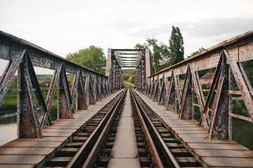 old metal train bridge over river