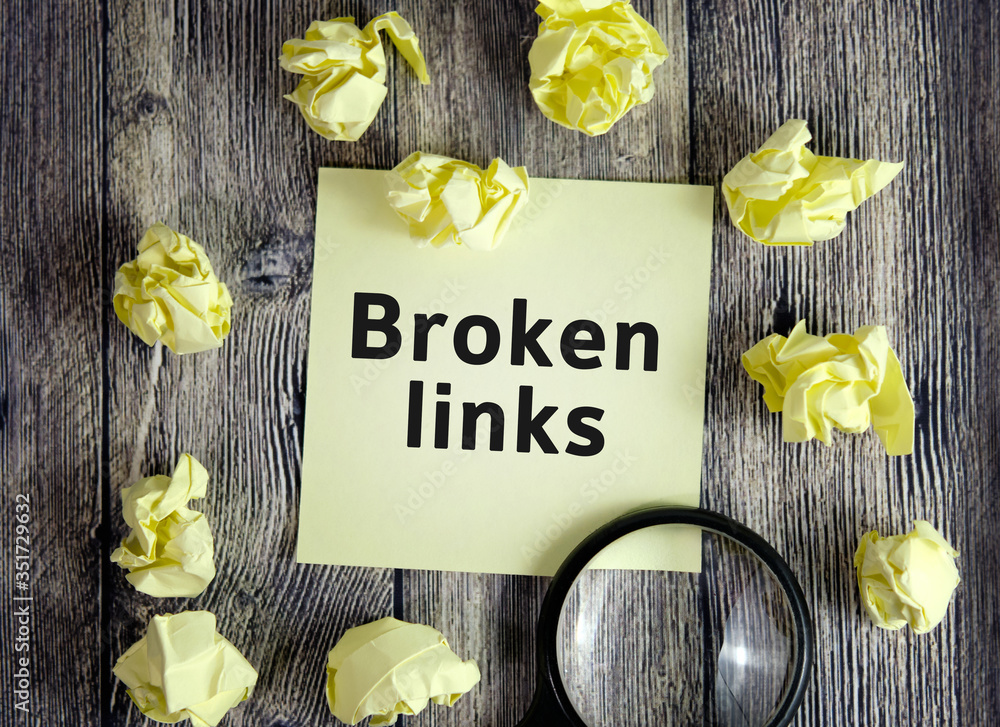 Poster broken links - text on yellow note sheets on a dark wooden background with crumpled sheets and a mag
