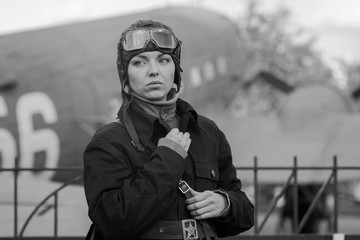 Retro style black and white photography. A young female pilot in uniform of Soviet Army pilots...