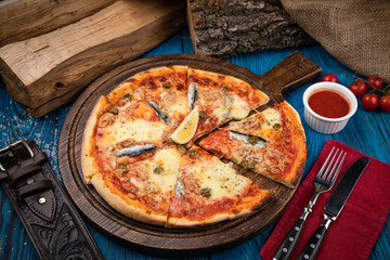 Italian pizza with fish on blue background