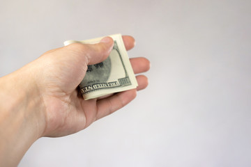 Hand with money on a gray background. The concept of payment, currency exchange, bribery.
