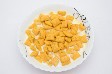 
chocolate-filled corn pads in a white porcelain plate with milk on a white background