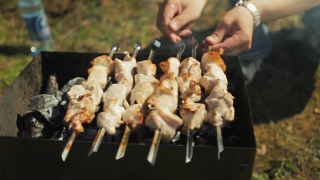 Chunks of meat on skewers are grilled on the grill.