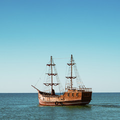 Fototapeta na wymiar Old wooden schooner goes by the sea.
