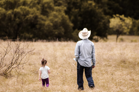 grandpa and granddaughter walking in the pasture