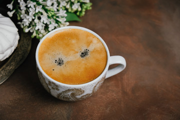 Cup of italian espresso coffee and spring flowers.