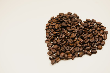 Heart shaped coffee beans on white background
