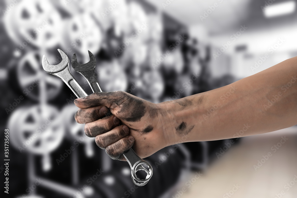 Wall mural Mechanic with wrenches at tire shop, closeup