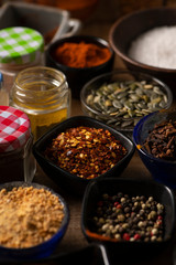Different Spices in small bowls on a wooden table