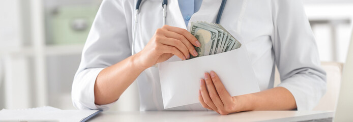 Doctor with bribe at desk in clinic, closeup. Banner design
