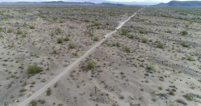 Quadbikers speeding along dirt path through desert in Arizona