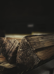 Chipped firewood lie near the fireplace on a dark background