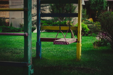 Fototapeta premium wooden swing on chains in the garden on a background of greenery