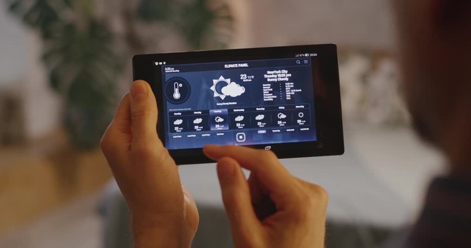 Man checking various functions on home hub