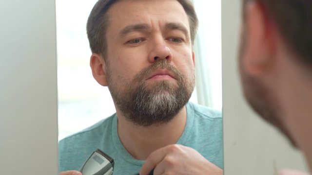 Man makes a haircut of beard razor. no money for the barbershop.