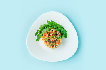 Healthy vegetarian lunch for little kids. vegetables and fruit served as funny human shaped. Fresh apple, carrot, sprouts, arugula, pumprin seeds on pastel blue background, flat lay.