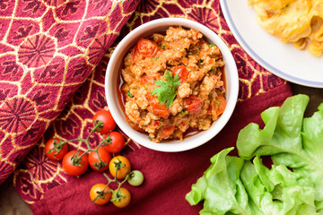 Northern Thai food (Nam Prik Ong), spicy chili minced pork with tomatoes in a bowl eating with vegetables and omelette, Thai chili paste