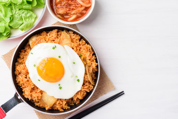 Kimchi fried rice with fried egg in small cooking pan on white table, Korean food, Top view