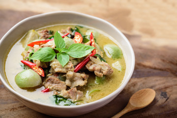 Thai food, Green curry with pork (Kang Keaw Wan) in a bowl and spoon on wooden background