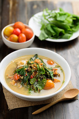 Northern Thai food (Kang Pak Seaw), Spicy soup with Bauhinia Purpurea leaf and roasted smoked fish in a bowl on wooden background
