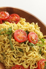 Asian food, cherry tomato and fried noodles on wooden plate
