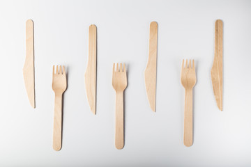 Wooden disposable environmentally friendly tableware top view on white background. eco hashtag