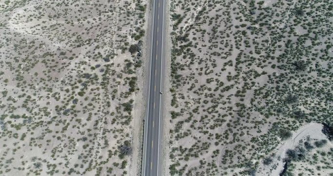 Pull back tracking motion with cyclist shows scale of the large flat environment in southern New Mexico