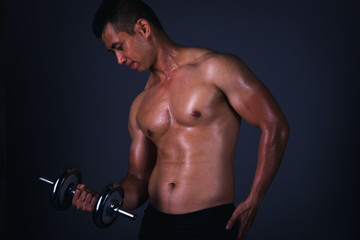 Fototapeta na wymiar Muscular model Asian young man on Gray background. Portrait of strong brutal guy with trendy hairstyle. Sexy naked torso, six pack abs. Male flexing his muscles. Sport workout bodybuilding concept.
