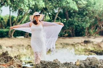 Happy free-spirited woman with open arms and a smile on her face in nature