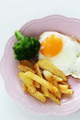 homemade French fries and sunny side up fried egg with broccoli 
