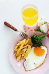 homemade French fries and sunny side up fried egg with broccoli 
