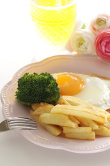 homemade French fries and sunny side up fried egg with broccoli 