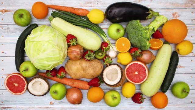 Fresh fruits and vegetables appear on wooden table - Stop motion 