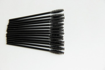 makeup artist set, lots of black mascara brushes on a white background close-up