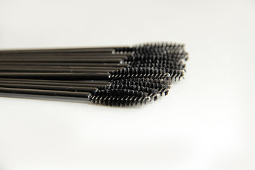 makeup artist set, lots of black mascara brushes on a white background close-up