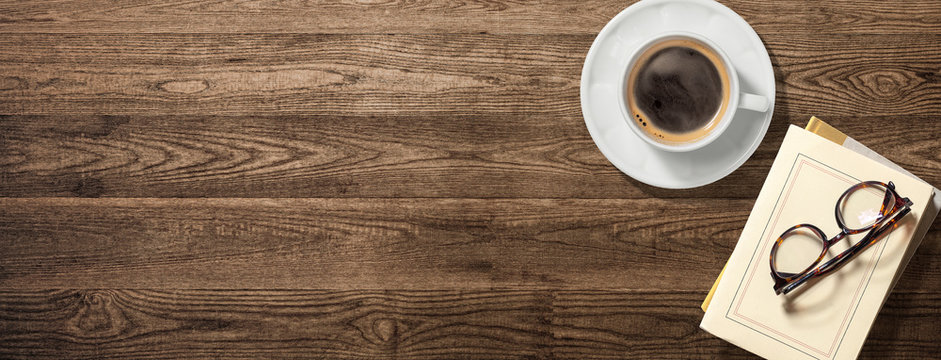 コーヒーカップ、本、眼鏡のある木製のテーブル