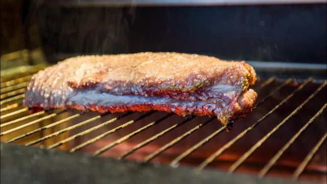 Beautiful photo of beef brisket (Brisket point end) on the grill with smoke.