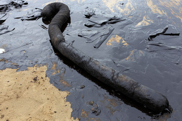 Used Oil Containment Boom on the sand beach that covered with Crude Oil on oil spill accident on Ao Prao Beach at Samet island on July 2013 in Rayong province, Thailand. © mrpeak