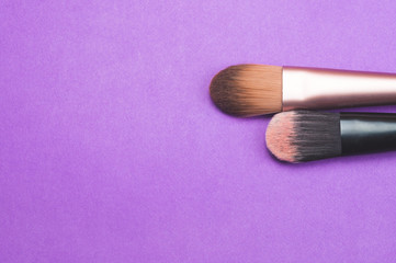 Makeup brushes on purple background. various cosmetic brushes. skin care accessories