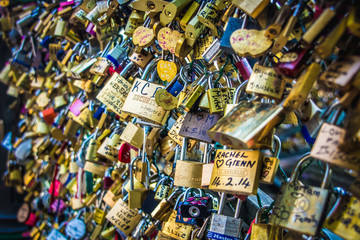 Several bridge locks with names of couples in love