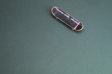 Small skateboard on color background. tiny skate for fingers. fingerboard close up