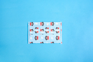 Baby medical protective mask printed with monkeys isolated on blue background. Coronavirus quarantine, hygiene concept