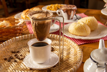 coffee strained straight into the cup on a table with cheese bread
