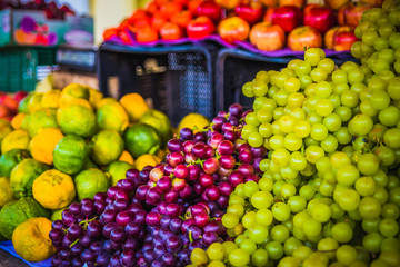 Fototapeta na wymiar grapes, tangerines and apples at market stall