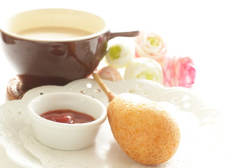 Corn dog and ketchup on dish for fast food
