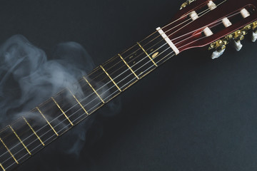 Guitar fretboard in smoke. musical instrument. strings on the guitar neck