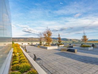 A rooftop deck with wall garden, outside lounge and chairs looking out toward a mountainous...