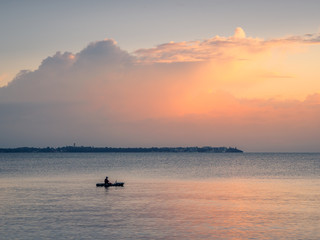 Small Boat at Sea with Dawn Cloudscape