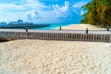 Wooden bridges leading to the huts on the shores of the tropical, warm sea. Maldives. Tourism concept.