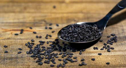 black sesame seeds on wood background
